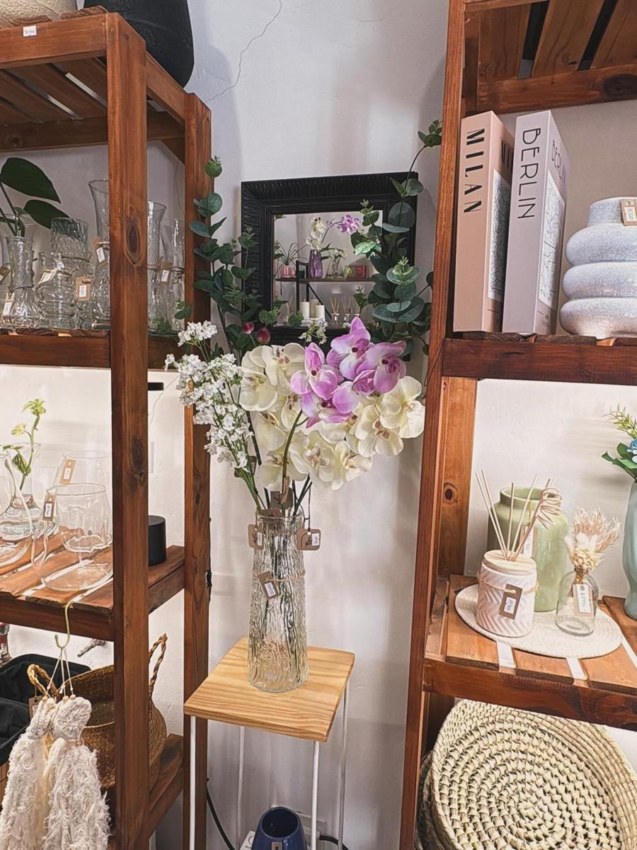 Pasillo del local con flores y estanterías